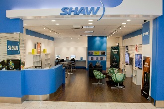 Magasin Shaw bleu et blanc avec des murs de présentation de produits, un comptoir de service et des fauteuils lounge verts.